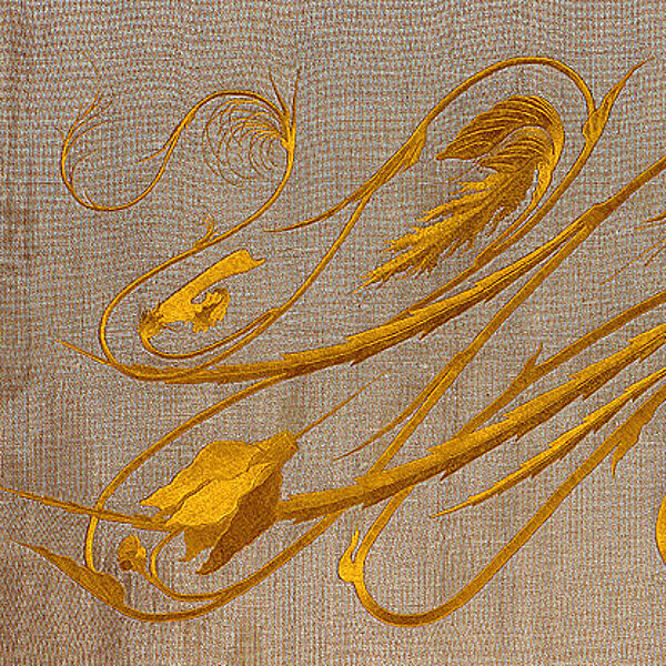 Stoff, kunstvoll bestickt mit einer goldfarbenen Ornamentik, abstrakt geschwungene Linien mit Pflanzenelementen.